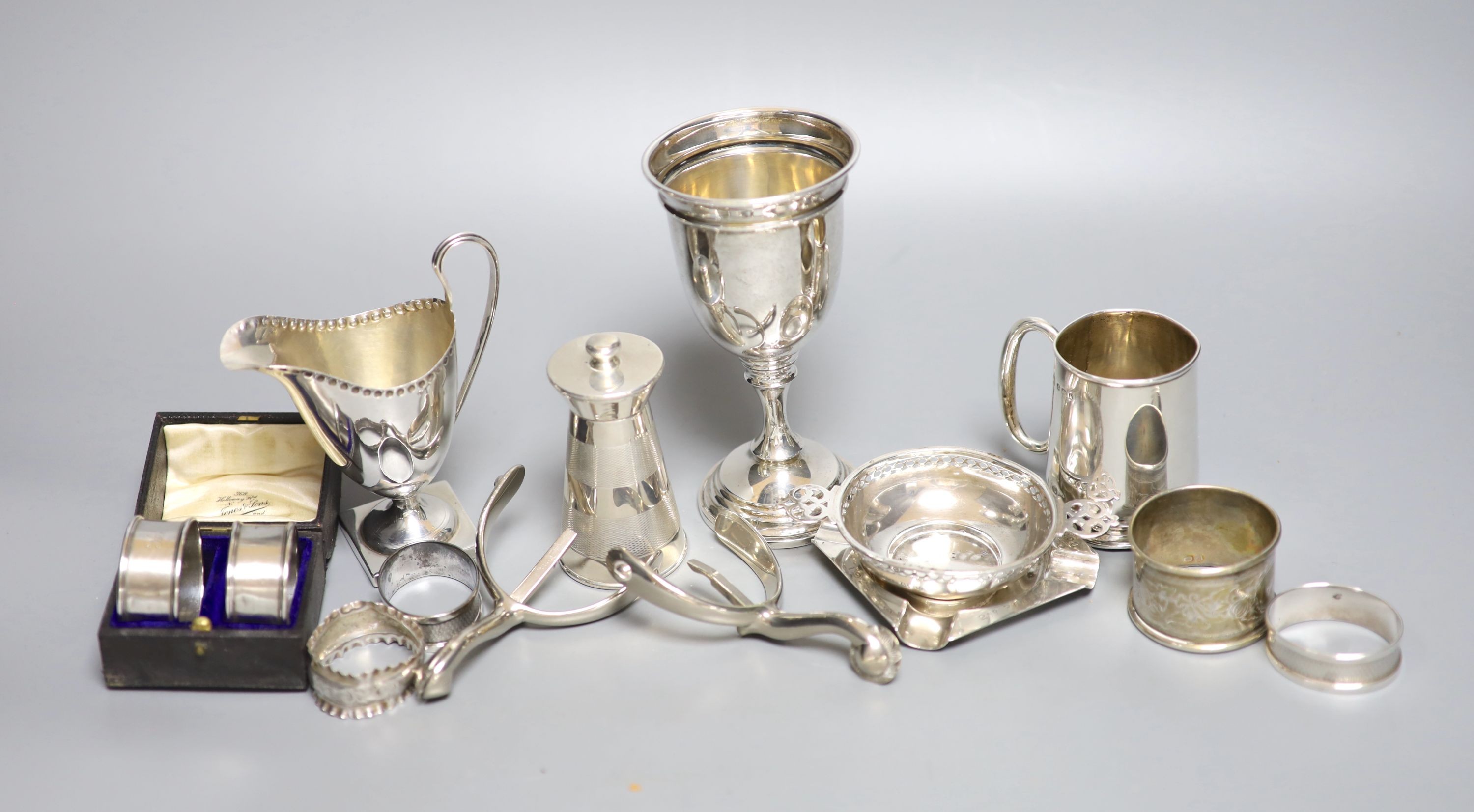 Mixed small silver lot to include a pepper mill, cream jug, christening mug, goblet, etc and a pair of metal spurs.